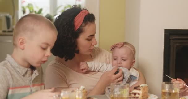 Чаепитие в семейном кругу. Мама дает ребенку попробовать кекс без глютена. — стоковое видео