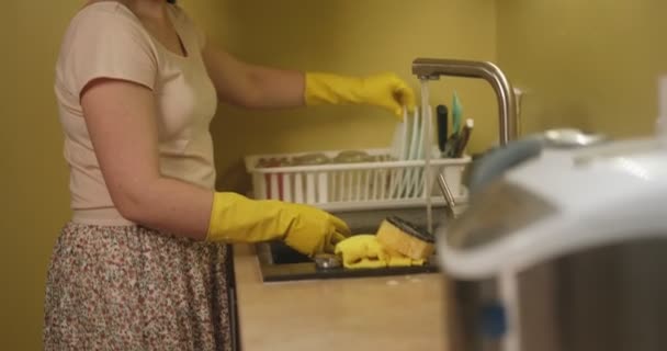 Η μητέρα πλένει πιάτα το απόγευμα. Ευθύνες κουζίνας. Πλένεις βρώμικα πιάτα στο νεροχύτη. — Αρχείο Βίντεο