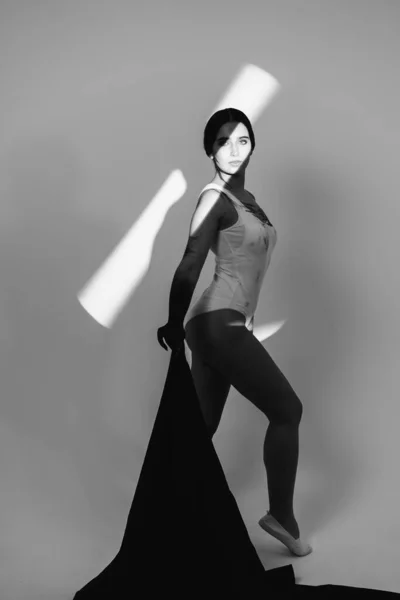 Photo of a real girl in the studio. Shadow on the face. Girls hand with black paint. Acceptance of your body.