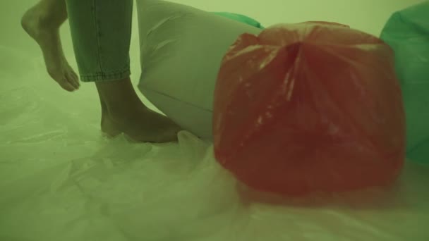 Verunreinigungen durch nicht recycelbare Tüten. Die Beine der Mädchen schieben die Taschen durch. — Stockvideo