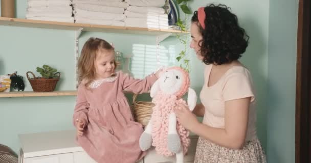 Mamma e figlia mettono a lavare il loro giocattolo preferito per bambini. Pulizia dei giocattoli durante la quarantena. — Video Stock
