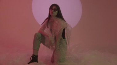 Stüdyoda etrafındaki her şeyin plastik olduğu bir fotoğraf çekimindeki kız. Arkandaki plastiği çıkar..