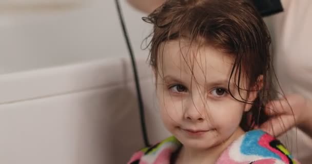 Les cheveux de bébé sont séchés. Visage de bébé près. Bébé en peignoir dans la salle de bain. — Video