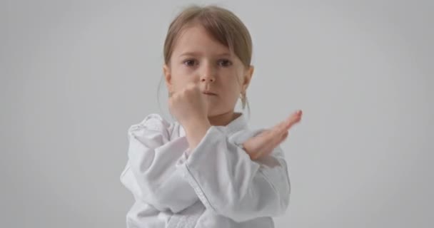 这个女孩重复空手道练习.穿和服的孩子做各种运动. — 图库视频影像