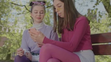 İki genç telefonda vakit geçirip temiz hava soluyor..