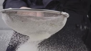 Un elek yoluyla masaya yayılır. Pasta için bir sürü ornaik un..