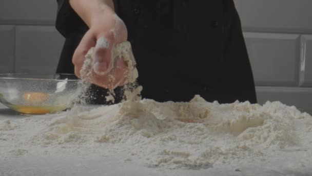 A amassar a massa. O confeiteiro amassa a farinha junto com o ovo. — Vídeo de Stock