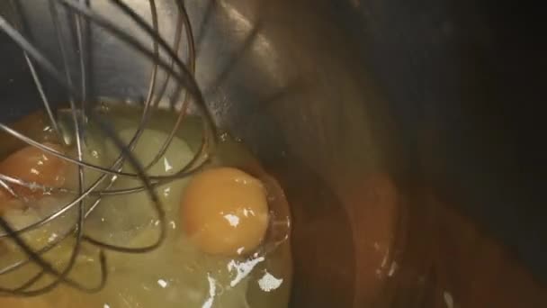 Миксер бьет яйца с сахаром вблизи. Этап приготовления десерта. — стоковое видео