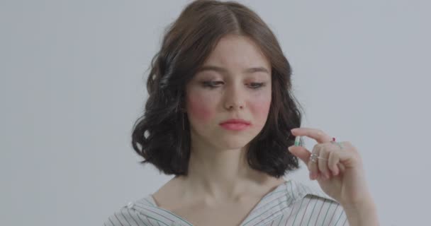 Gesicht eines jungen Mädchens mit verdorbenem Make-up in Großaufnahme. Weinendes Mädchen nimmt Antidepressiva. — Stockvideo