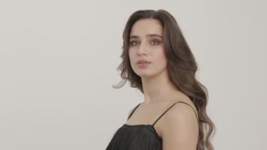 Beautiful girl with hair and makeup looks at the camera.