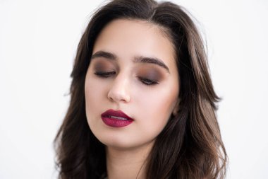 Girls face close up. Studio makeup. Bright lips. Thick and dark eyebrows.