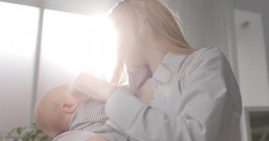 Anne sevgisi. Güzel bir anne çocuğunu kollarına alır ve ona hayranlık duyar..