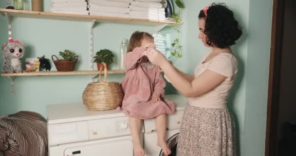 La madre enseña a su hija a armar las cosas correctamente desde la infancia. Trabajos domésticos. — Vídeos de Stock