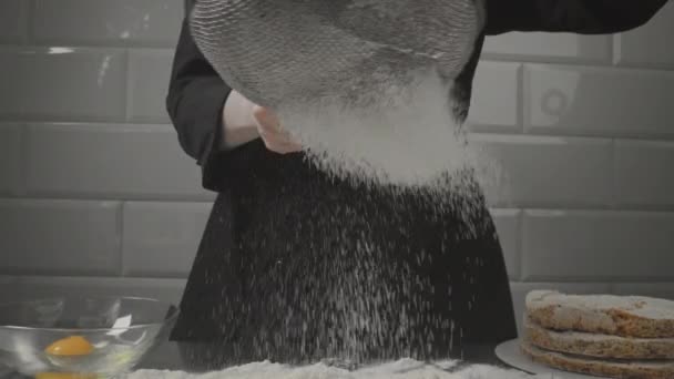 Кондитер просіює борошно через сито. Перший етап приготування торта . — стокове відео