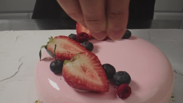 Legen Sie saisonales Obst auf den Kuchen. Erdbeeren in Scheiben geschnitten und Blaubeeren Kuchen Dekoration. — Stockvideo