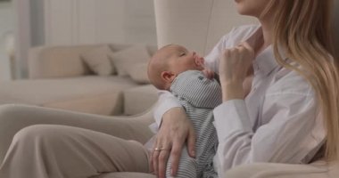 Bebek ağzında bir emzik ile annesinin kollarında uykuya daldı..