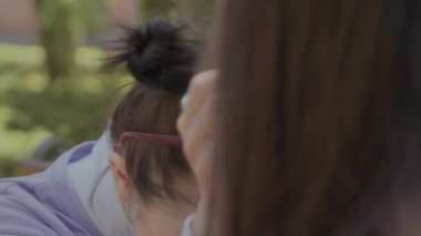 Kızlar birbirlerini şeker ile besler ve mutlu bir şekilde gülerler. Parkta lezzetli bir tatlı karışımı..