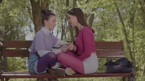 Duas raparigas sentadas ao lado uma da outra. Adolescentes meninas apaixonadas por uma menina. — Vídeo de Stock