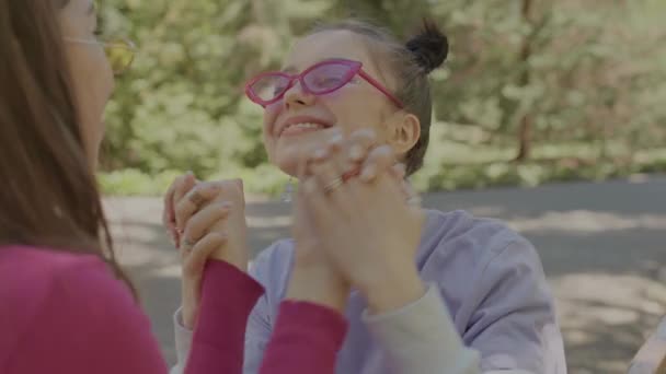 As meninas em copos brilhantes passam o tempo em conjunto no amor. Meninas passam o tempo juntos no parque. — Vídeo de Stock