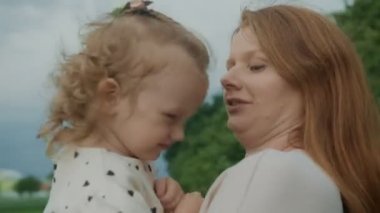 Doğada annelerin kollarında bir kız. Anne çocuğa doğayı sevmeyi ve saygı göstermeyi öğretir..