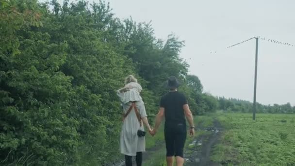 Keluarga berjalan di hutan hijau. Ibu menggendong bayi di bahunya.. — Stok Video