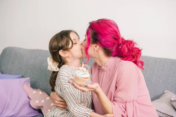 mother tenderly kisses her daughter on her birthday