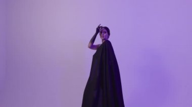 Stüdyoda, üzerinde siyah bir bez olan neon ışıklı bir kız..