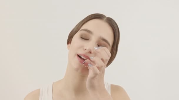 A rapariga limpa o rosto de migalhas de comida. Menina bonita limpa em um fundo branco. — Vídeo de Stock