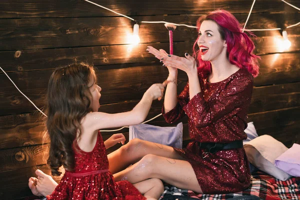 Mor leker med sin dotter med olika kosmetiska verktyg — Stockfoto