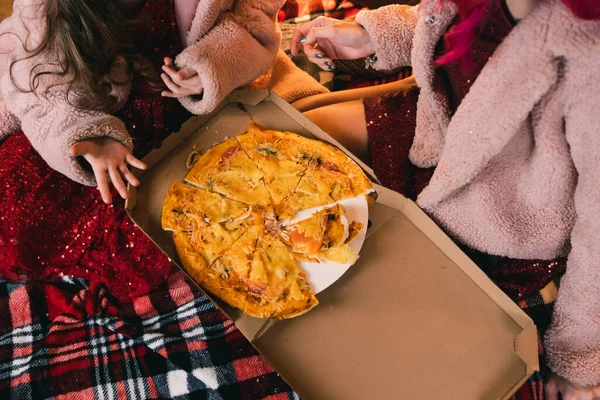 Anne ve kızı evde çekilen bir fotoğraf çekiminde güzel kokulu pizzanın tadını çıkarıyorlar.