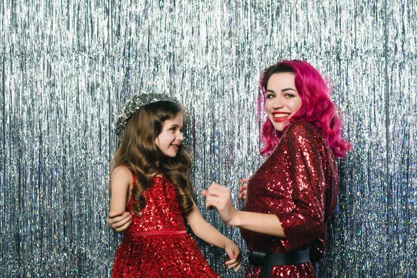 Anne ve kızı fotoğraf çekimi sırasında kamerada ritmik olarak dans ediyorlar.