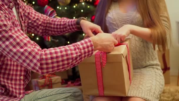 Primo piano di una moglie incinta che disfa un regalo dal marito per il nuovo anno — Video Stock
