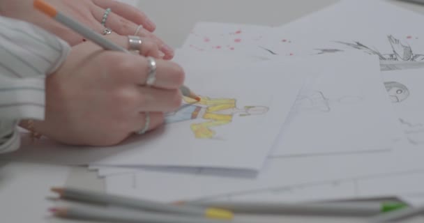 Manos frágiles de una chica haciendo un dibujo. Joyería de plata en los dedos. — Vídeo de stock