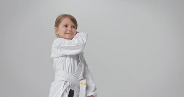 El niño realiza un ejercicio especial para el karate. Un atleta diligente realiza varios ejercicios. — Vídeos de Stock