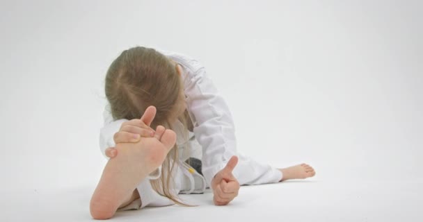 Kleine babyvoetjes van dichtbij. Het meisje reikt naar haar been om flexibeler te worden.. — Stockvideo