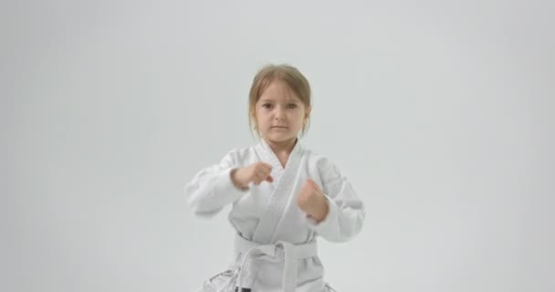 A child dressed in a kimono puts his hands to her ear, takes them and straightens. — Stock Video