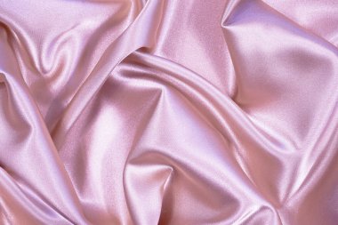 Pembe ipek saten arka plan. Kumaşın üzerinde yumuşak dalgalı kıvrımlar var. Düğün, yıldönümü, sevgililer günü, aşk, şefkat, bayram, kutlama, kart. Tasarımınız için kopyalama alanı olan güzel pembe soyut arkaplan                               