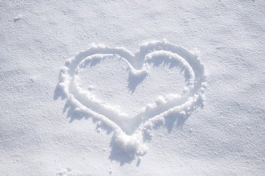 Taze kara yakın çekim güneşi. Aşk, Sevgililer Günü, duyguların ifadesi, mutluluk kavramı. Tek kalp beyaz kar arkaplanında.