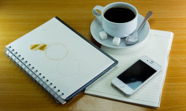 Natürmort fincan kahve tabağı ile defter ve smartphone üzerinde 