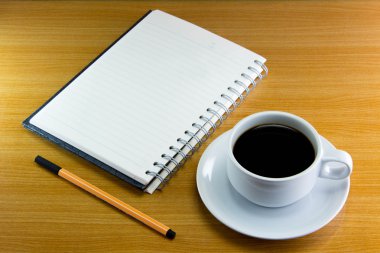 Natürmort fincan kahve üzerinde uçan daire ile defter ve kalem ahşap üzerine