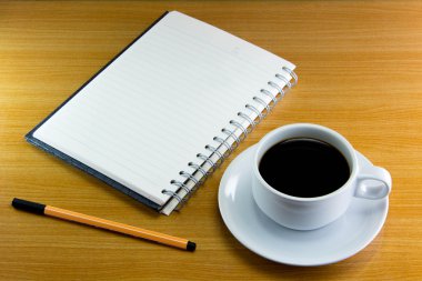 Natürmort fincan kahve üzerinde uçan daire ile defter ve kalem ahşap üzerine
