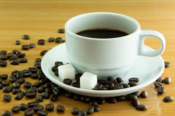 Bodegón Una taza de granos de café con azúcar cúbica — Foto de Stock