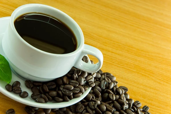 コーヒー豆とコーヒー木製テーブルの上の静物カップ — ストック写真