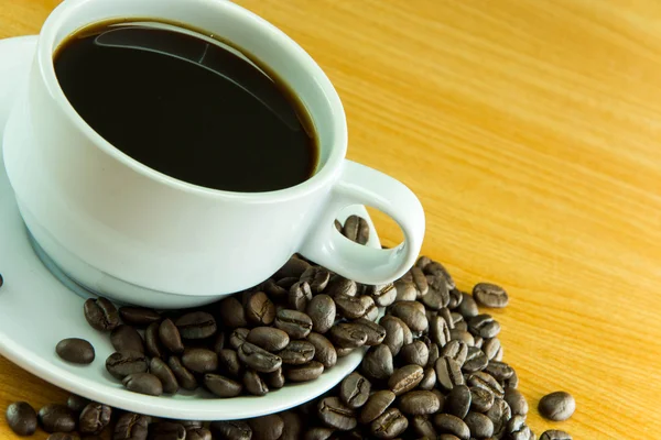 Stilleven kopje koffie bonen op houten tafel — Stockfoto