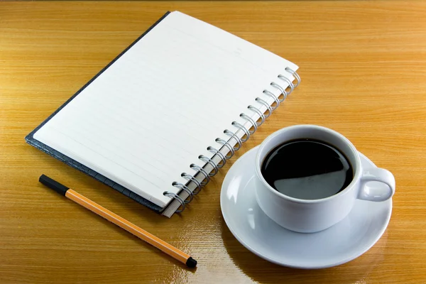 Natürmort fincan kahve üzerinde uçan daire ile defter ve kalem ahşap üzerine