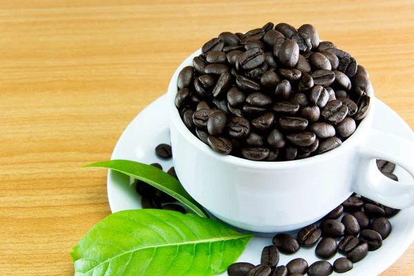 Still life Cup of coffee beans and leaves coffee on wooden table — Stock Photo, Image