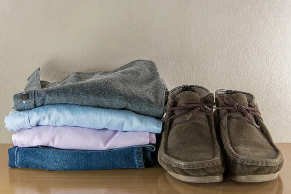 Casual adam ve ahşap masa grung üzerinde bot ile natürmort