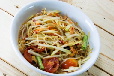 Yeşil papaya Salatası Tay gıda tarzı ahşap arka plan üzerinde.