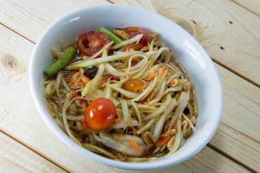 Yeşil papaya Salatası Tay gıda tarzı ahşap arka plan üzerinde.