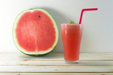 Ahşap masa üzerinde bardak taze karpuz suyu ile nane yaprakları